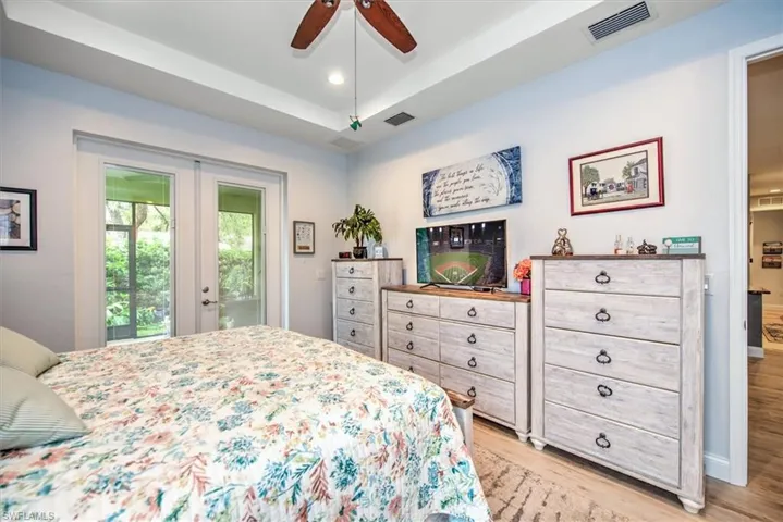 Bedroom featuring ceiling fan, light wood-type flooring, french doors, and access to exterior