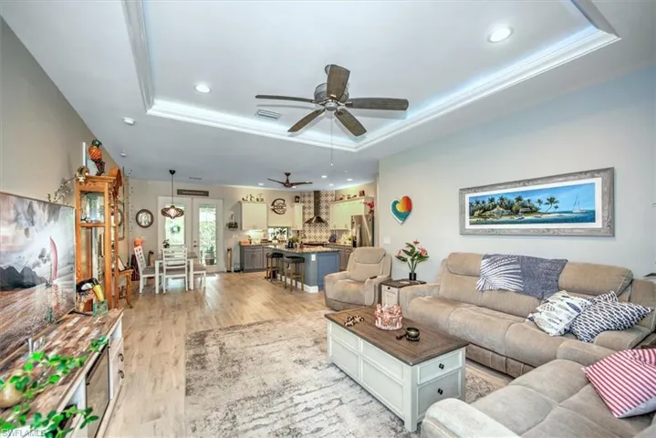 Living room with coffer ceilings, fan, crown molding and  wood-style floors