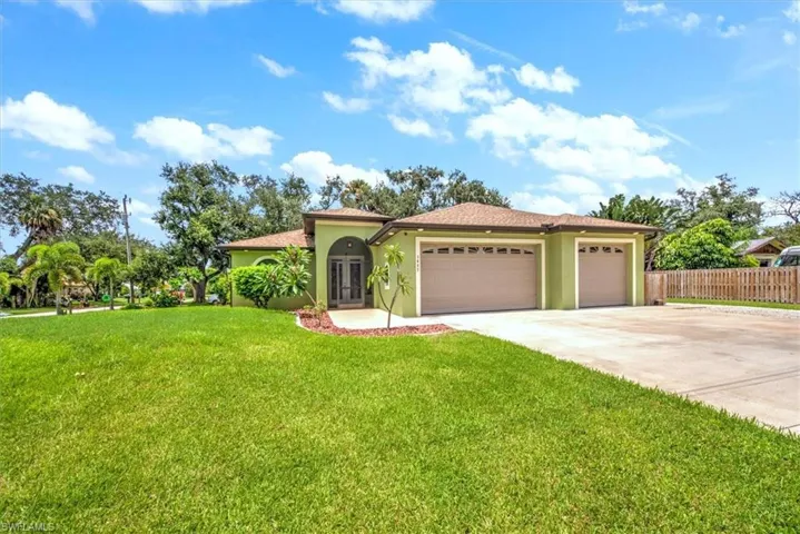 View of home with large front yard and a garage