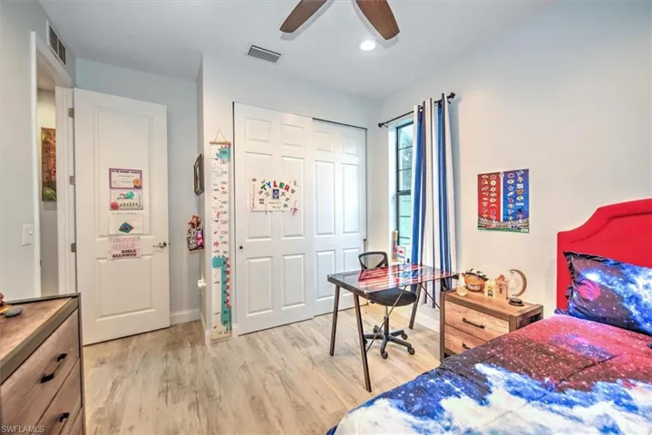 Bedroom featuring ceiling fan, light wood-type flooring, and a closet