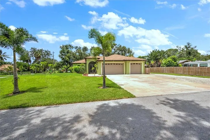 View of front of house featuring a front lawn and a garage
