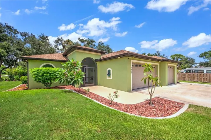 View of home featuring a garage and a front lawn