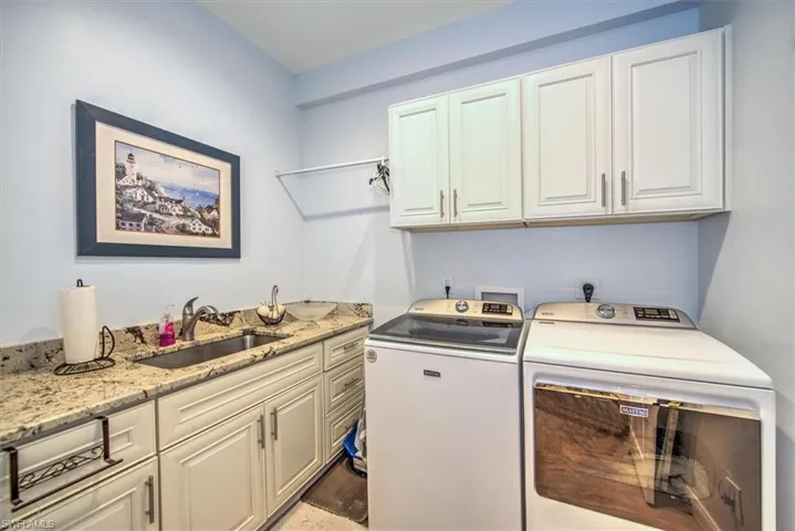 Washroom with sink, cabinets, and separate washer and dryer