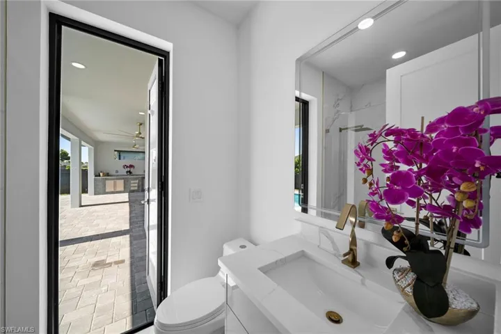 Bathroom with ceiling fan, vanity, and toilet