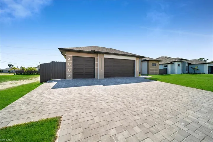View of front of home with a garage and a front lawn
