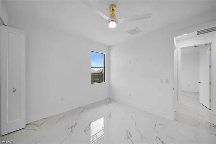 Tiled spare room with ceiling fan