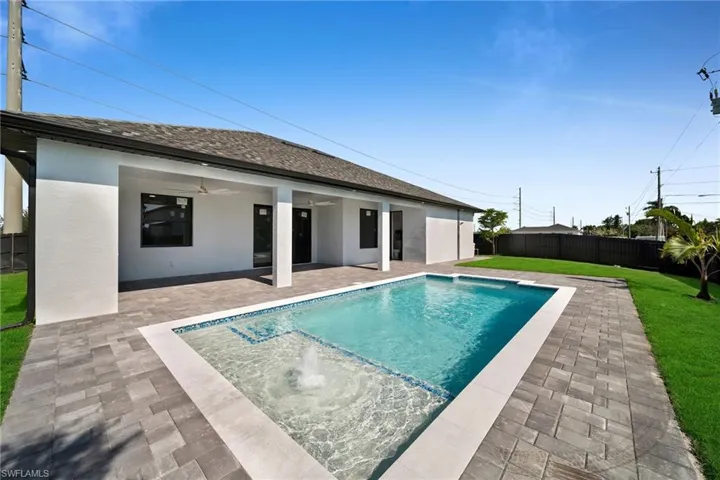 View of pool featuring ceiling fan, a lawn, and a patio