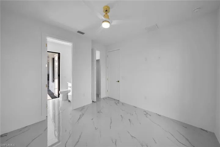 Empty room featuring ceiling fan and light tile floors