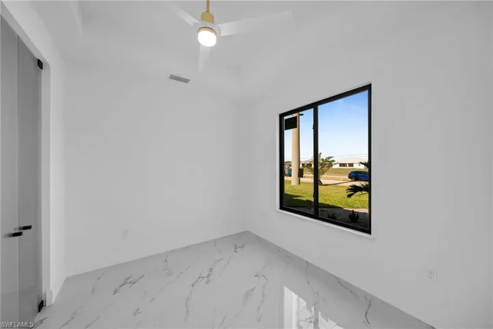 Tiled empty room featuring ceiling fan
