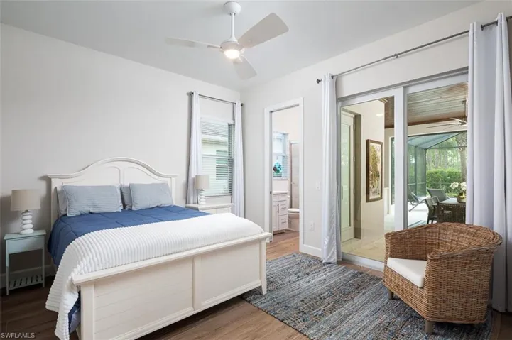Bedroom featuring wood finished floors, ensuite bathroom, and ceiling fan