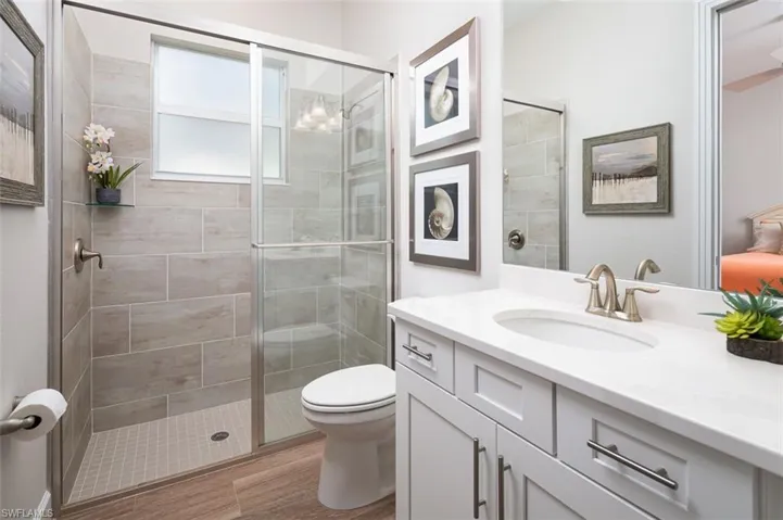 Bathroom featuring vanity, a shower stall, and wood finished floors