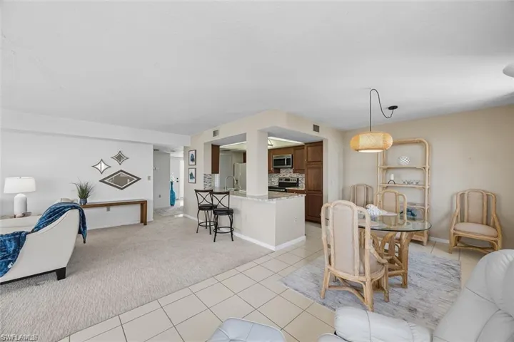 Dining space featuring light colored carpet and light tile patterned floors