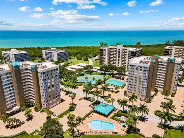 Aerial view of a pool area and a large body of water