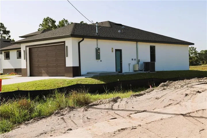 Stucco exterior with a dark shingle roof, and glass door front garage