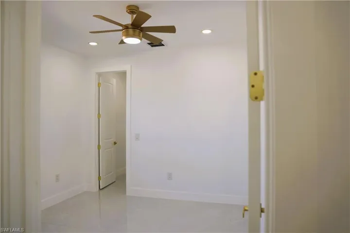 Recessed lighting, a ceiling fan with integrated lighting, and polished flooring enhance the interior space