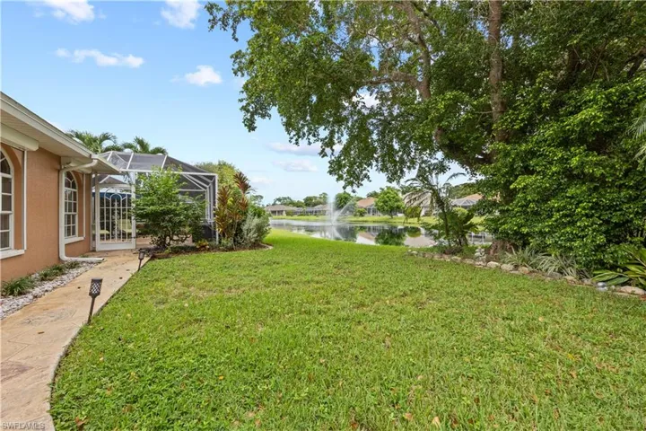 View of yard featuring a water view and enclosed lanai area