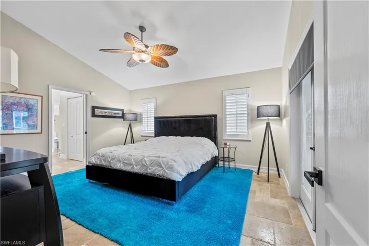 Primary Bedroom featuring vaulted ceiling and access to enclosed lanai area