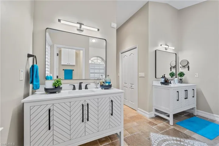 Dual sinks in primary bathroom with new vanities and lightning.