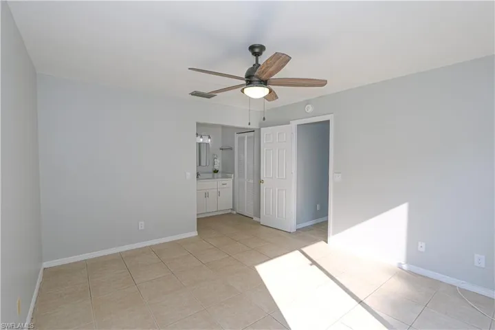 Primary bedroom with light tile patterned flooring