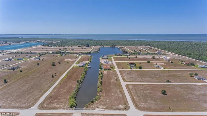 Aerial view of property's location with a large body of water