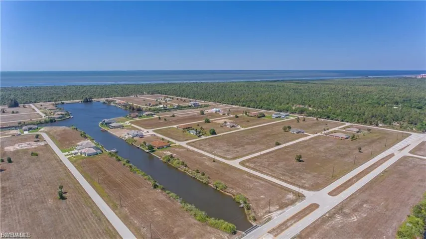 Drone / aerial view of a nearby body of water and a forest