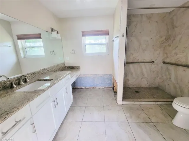 Secondary Bathroom with White Shaker Cabinets & Granite Countertops & Shower