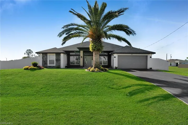 View of front of property featuring a garage and a front yard