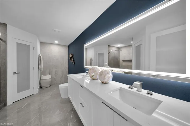 Bathroom featuring vanity, a shower with door, and toilet