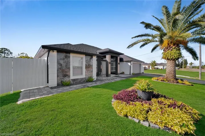 View of front of home featuring a garage and a front yard