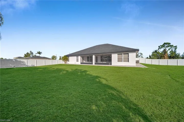 Rear view of property with a lawn