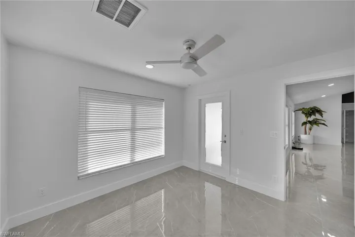 Unfurnished room featuring a wealth of natural light and ceiling fan