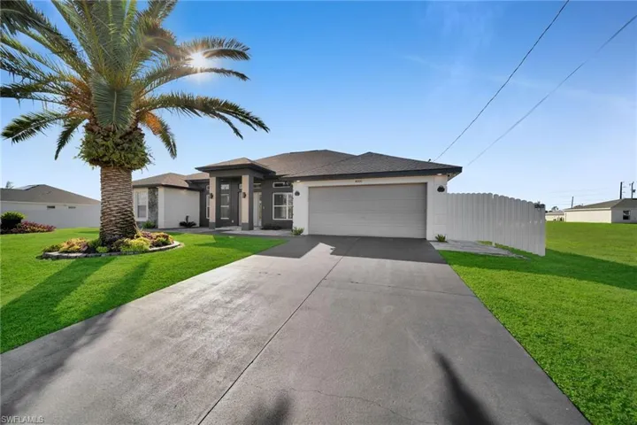 View of front of property featuring a garage and a front yard