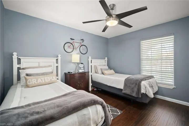 Bedroom with dark wood-type flooring and a ceiling fan