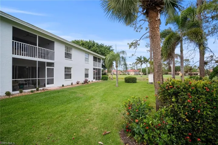 View of grassy yard with a sunroom
