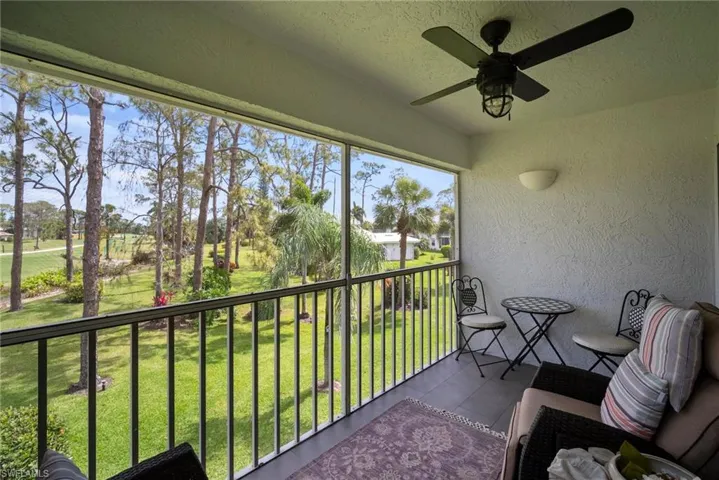 Sunroom / solarium with a balcony and a ceiling fan