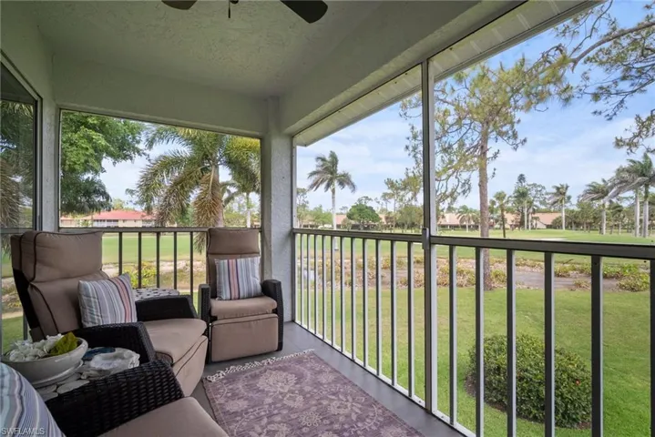 Sunroom / solarium featuring a balcony, a ceiling fan, and a residential view
