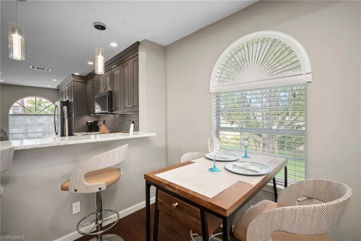 Dining room with dark wood-style floors and recessed lighting