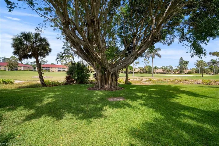 View of green lawn with a residential view and golf course view