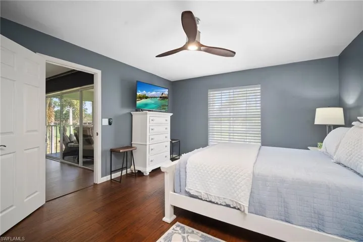 Bedroom with access to outside, dark wood finished floors, and ceiling fan