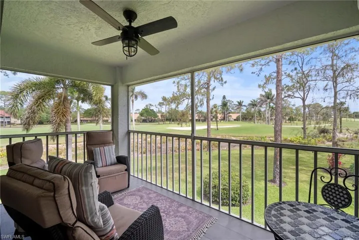 Sunroom / solarium featuring golf course view, ceiling fan, and a balcony