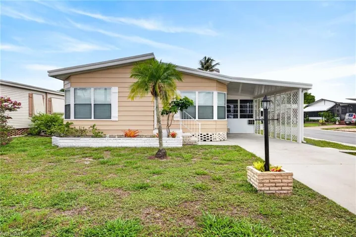 Single-story residence featuring horizontal siding, a covered carport, and a concrete driveway