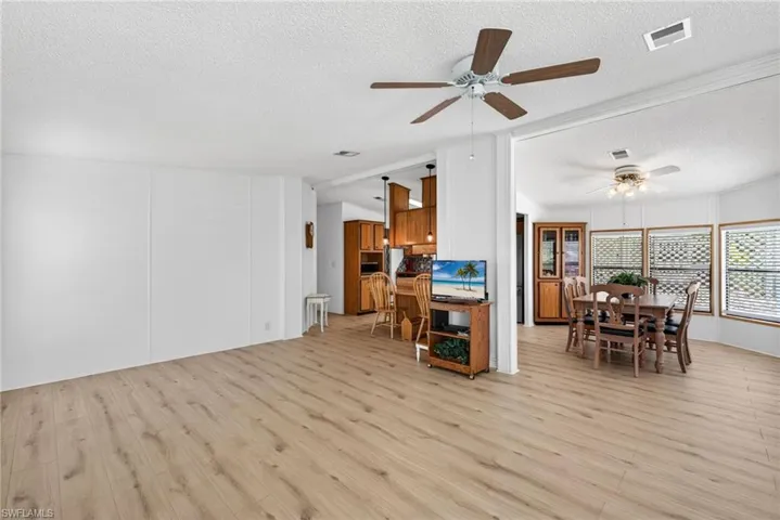 Bright interior space featuring wood-finish flooring, white walls, and ceiling fans