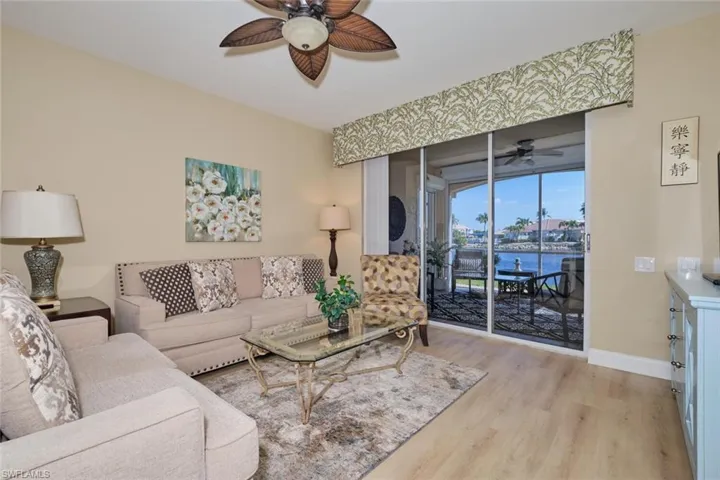 Living room with ceiling fan, light hardwood / wood-style flooring, and a water view