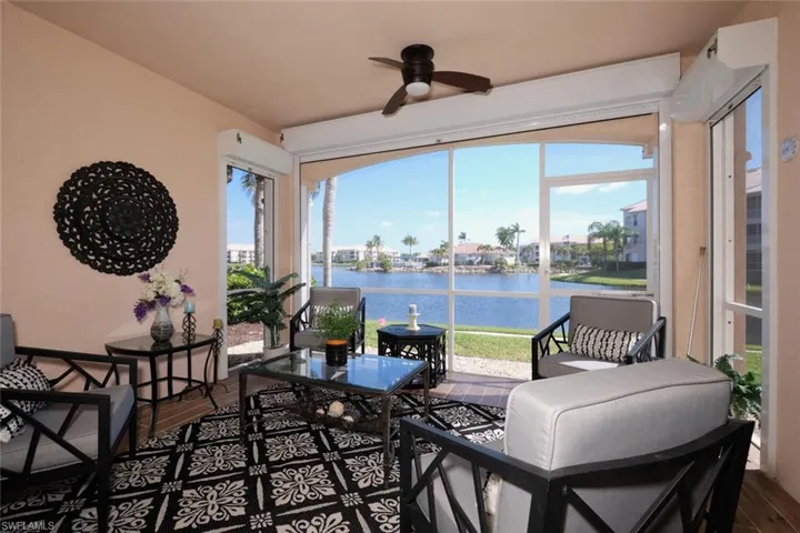 Sunroom featuring ceiling fan and a water view