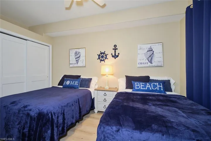 Bedroom with light hardwood / wood-style flooring, a closet, and ceiling fan