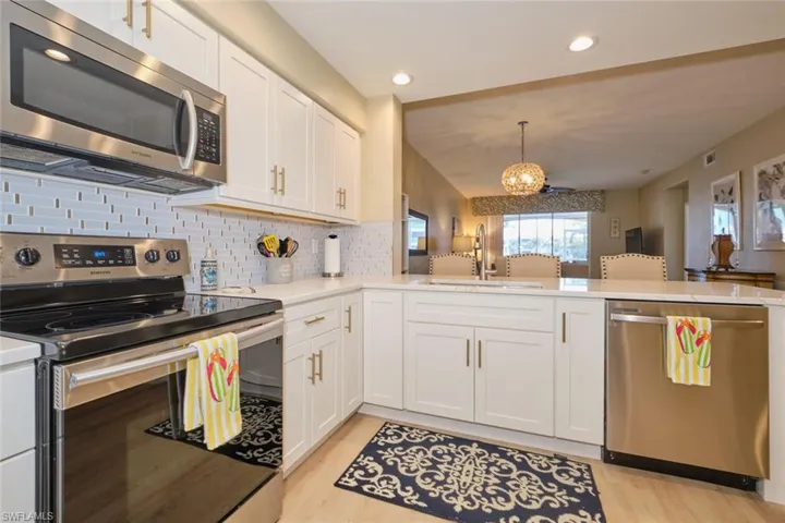 Kitchen featuring sink, white cabinets, kitchen peninsula, and appliances with stainless steel finishes