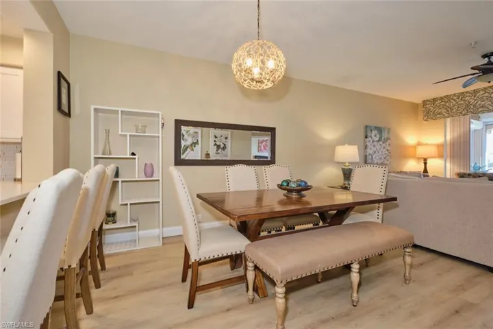 Dining space with ceiling fan with notable chandelier and light hardwood / wood-style flooring