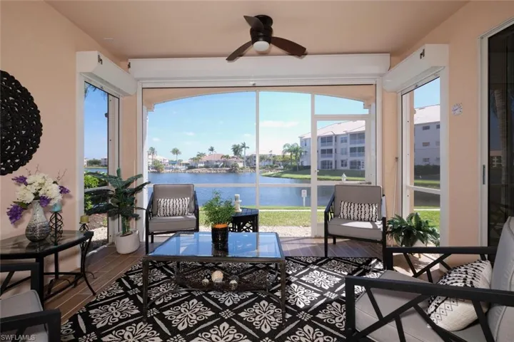Sunroom with ceiling fan and a water view