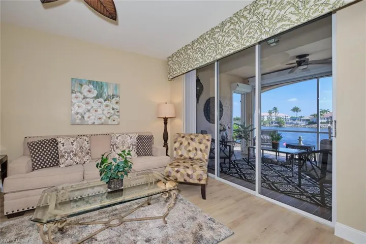 Living room featuring ceiling fan, hardwood / wood-style flooring, and a water view