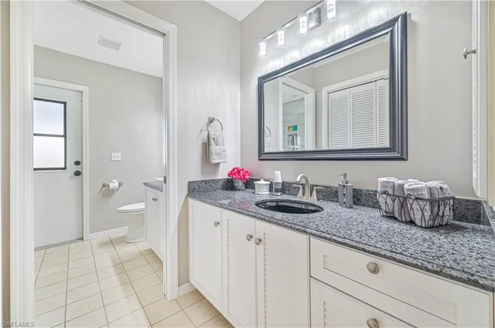 Bathroom with vanity, toilet, and tile patterned floors